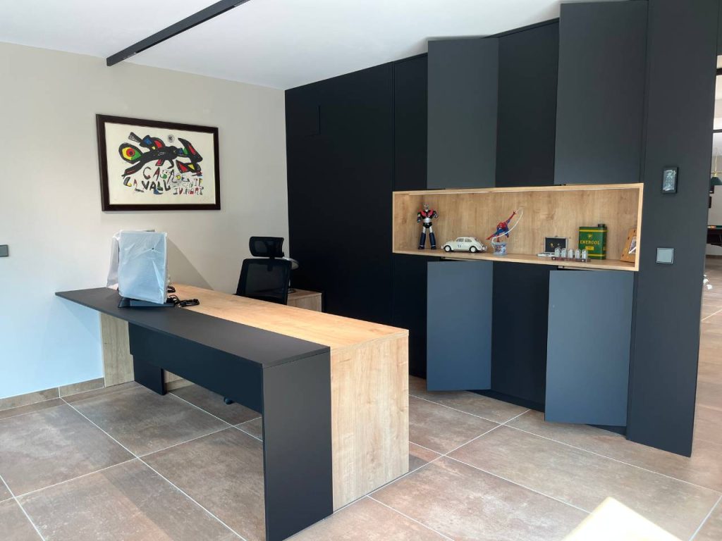 Despatx amb mobles negres i taulell de fusta en un projecte de reforma